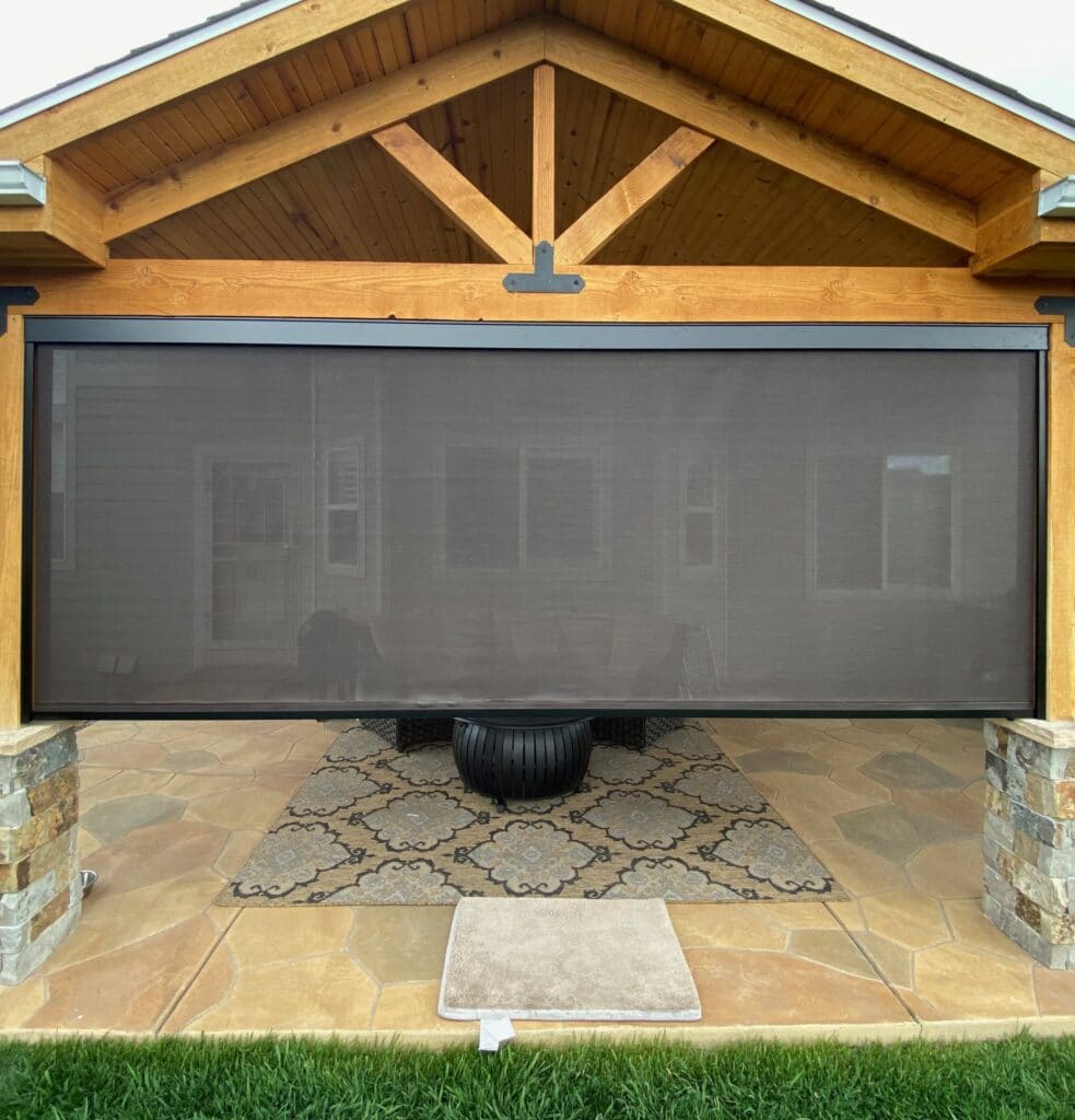 Black outdoor retractable patio sun shade partially rolled down